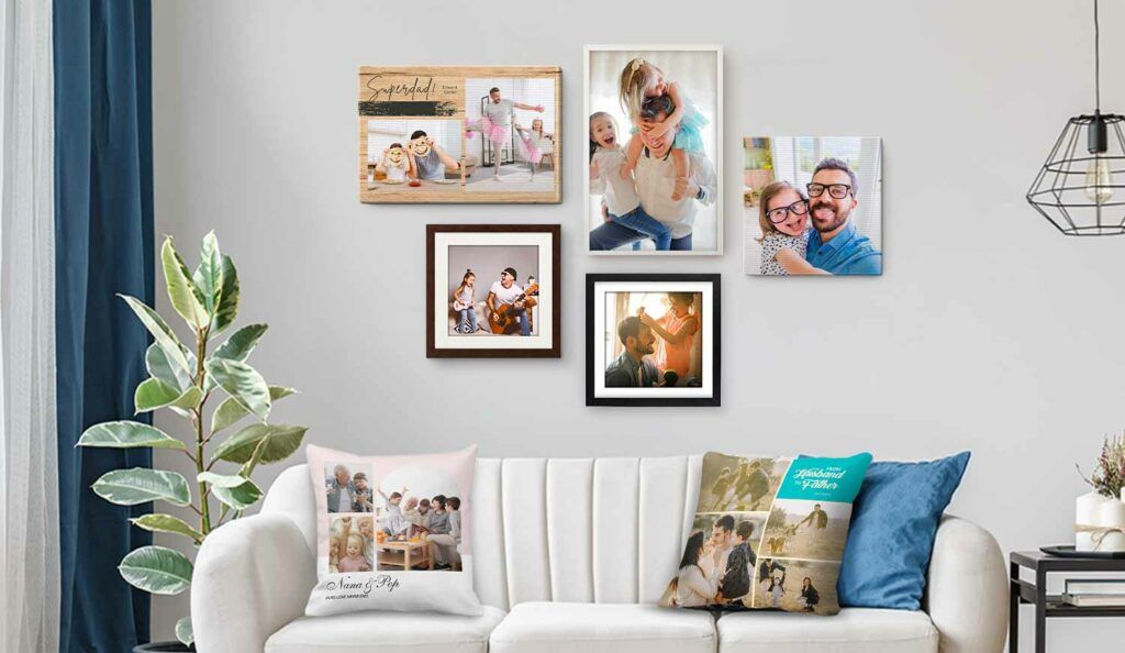 Gallery wall of framed family photos and a canvas print above a white sofa with photo cushions in a living room
