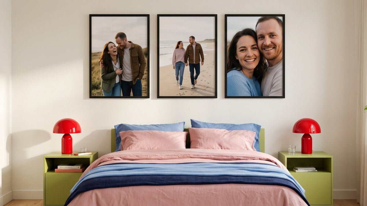 Three black-framed photos of a couple hanging above a bed with pink bedding and red lamps